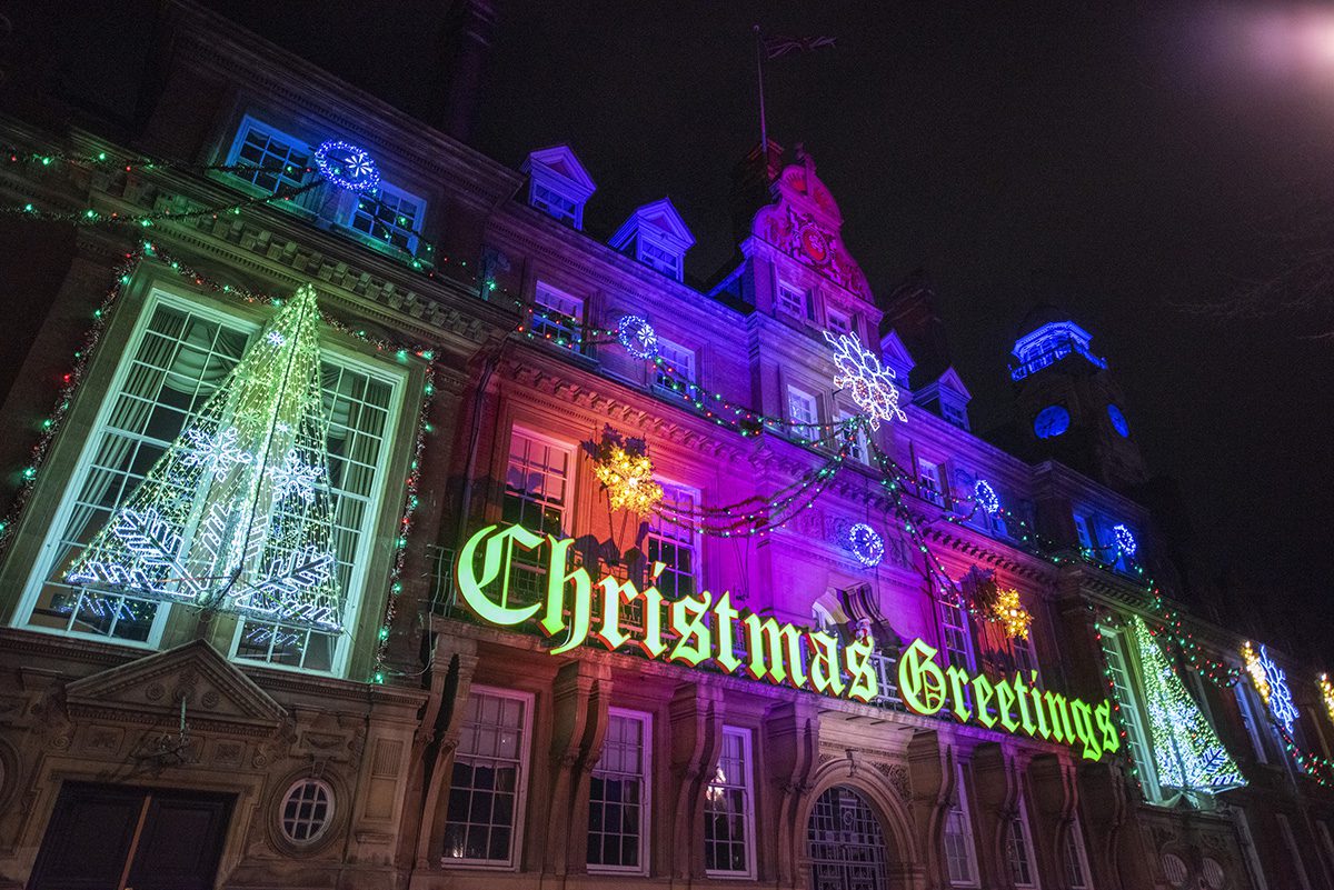 A Christmas Greetings light up sign with christmas lights at Town Hall Square in Leicester