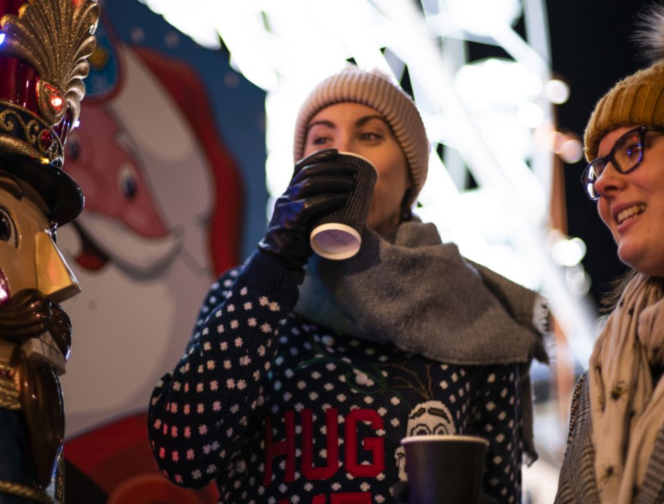 Two women dressed in winter clothing drinking hot chocolates