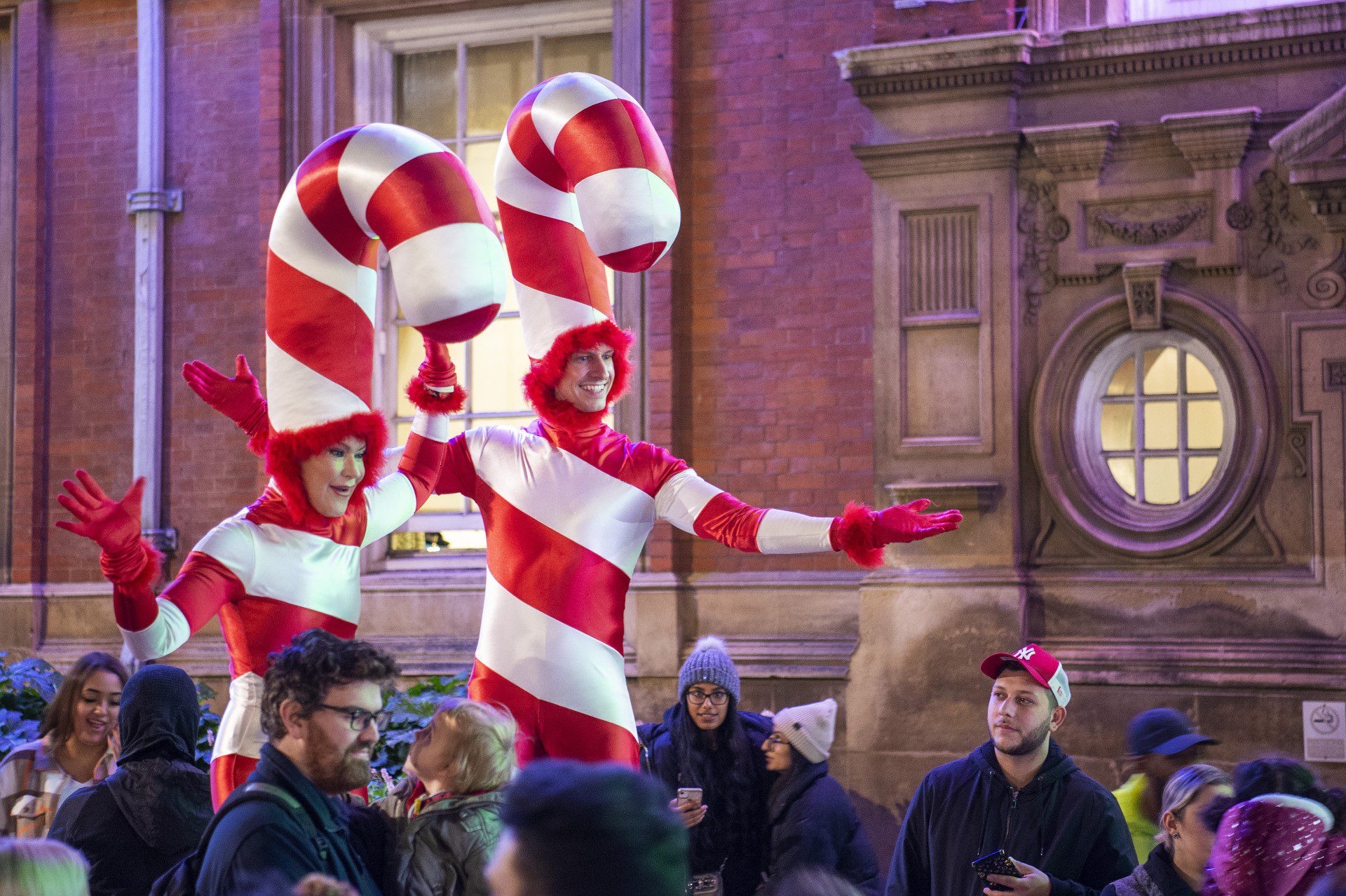 Two people dressed as candy canes among a crowd at Town Hall Square in Leicester