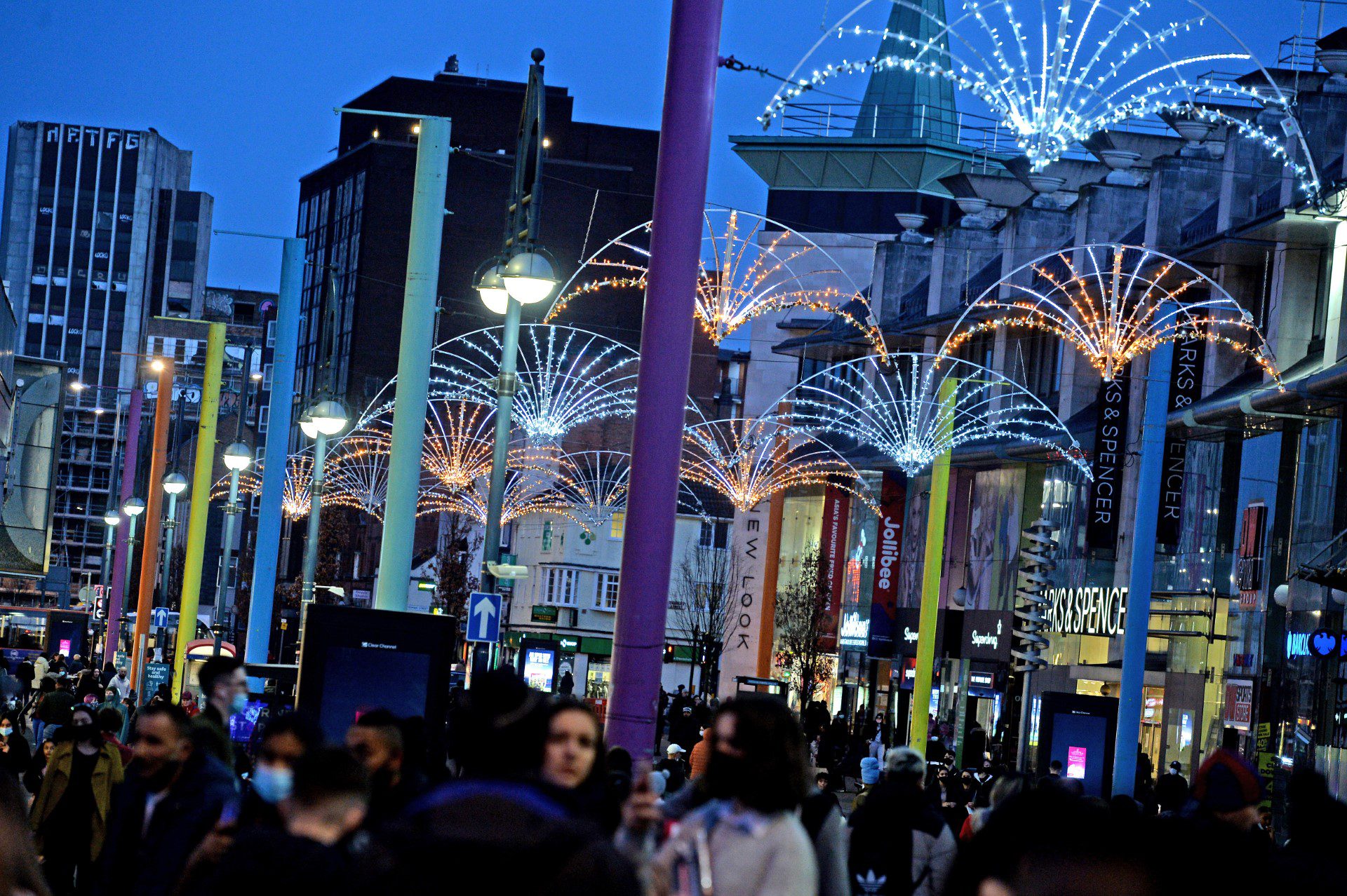 Crowds of people walking under the christmas lights in Leicester City centre